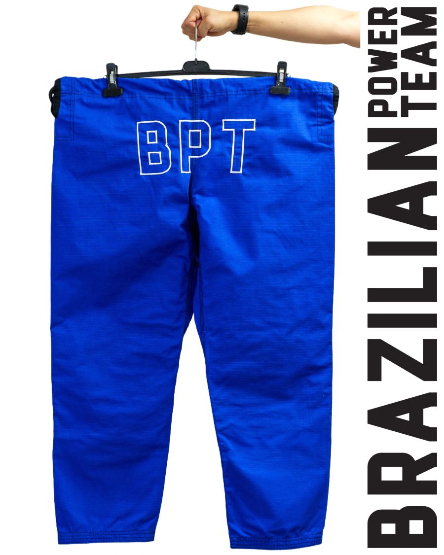 Blue BPT gi trousers hanging on a rail with Brazilian Power Team lettering.
